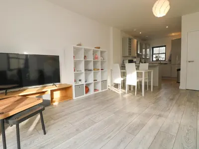 a living room with a table and a large screen tv at 1 Queensway Gardens in Hayle