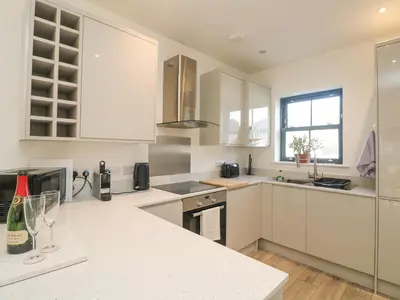 a kitchen with white cabinets and a white counter top at 1 Queensway Gardens in Hayle