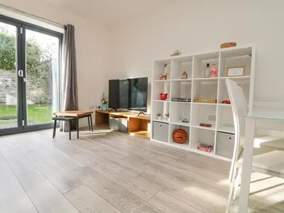 a living room with a table and a television at 1 Queensway Gardens in Hayle