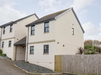 a white house with a wooden fence at 1 Queensway Gardens in Hayle