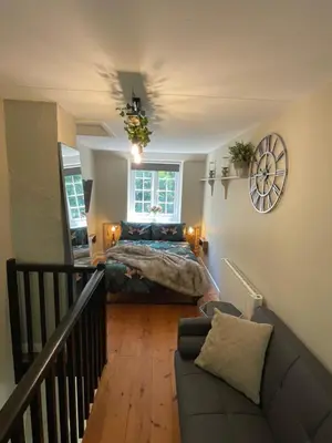 a bedroom with a bed and a couch at The Little Chapel Annexe in Helston
