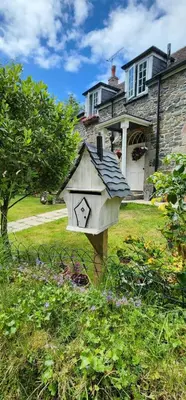 a bird house in the yard of a house at The Little Chapel Annexe in Helston