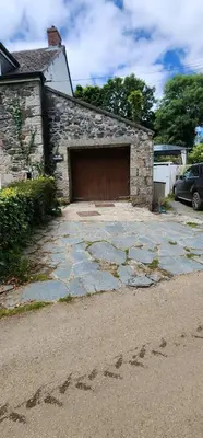 a garage with a brick building with a wooden door at The Little Chapel Annexe in Helston