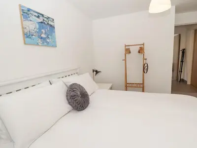 a white bed with white pillows in a bedroom at Sea Holly in St Ives