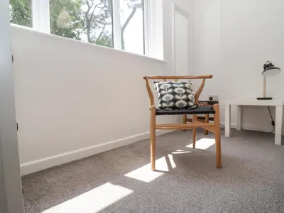 a chair sitting in a room with a window at Sea Holly in St Ives