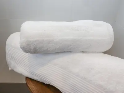 a stack of white towels sitting on a table at Sea Holly in St Ives