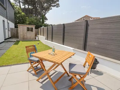a wooden table and two chairs on a patio at Sea Holly in St Ives