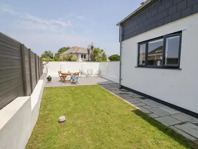 a small backyard with a patio and grass at Sea Holly in St Ives