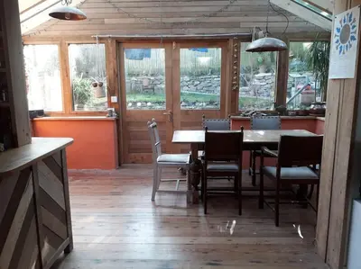 a dining room with a table and chairs and windows at Bright cosy house, garden, central to town & beach in Falmouth