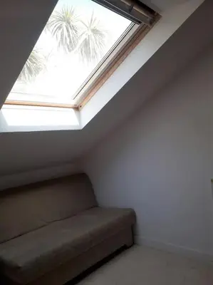 a skylight in a room with a couch under a window at Bright cosy house, garden, central to town & beach in Falmouth