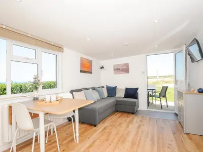 a living room with a couch and a table at Lundy View Chalet in Bude