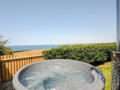 a bath tub with water in it on a balcony at Lundy View Chalet in Bude