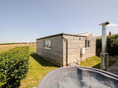 a bath tub in front of a tiny house at Lundy View Chalet in Bude