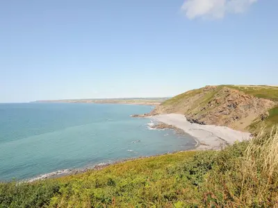 a view of a beach from a hill with the ocean at Lundy View Chalet in Bude