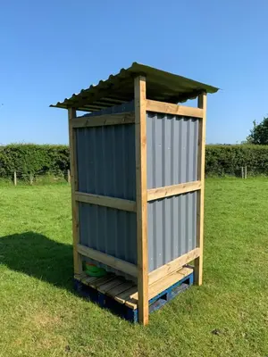 a wooden outhouse with a roof on a grass field at Rescorla Retreats- Poldark in Mevagissey