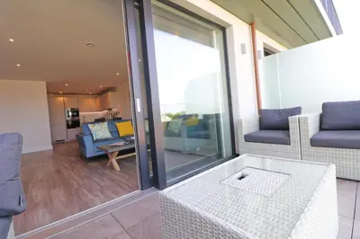 a living room with a couch and a table at Sea view apartment, first floor in St Merryn