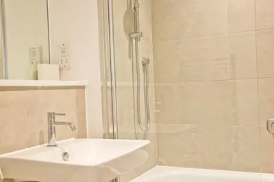 a bathroom with a sink and a shower at Sea view apartment, first floor in St Merryn