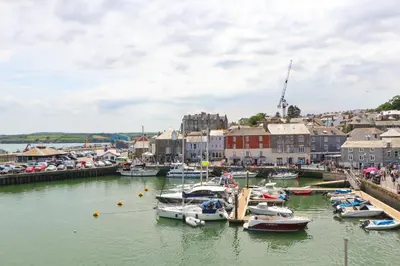 a bunch of boats are docked in a harbor at Sea view apartment, first floor in St Merryn