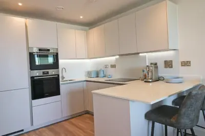 a kitchen with white cabinets and a counter top at Sea view apartment, first floor in St Merryn