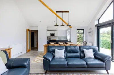 a living room with a blue leather couch at The Garden House in Wadebridge