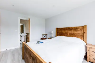 a bedroom with a large bed with a wooden headboard at The Garden House in Wadebridge