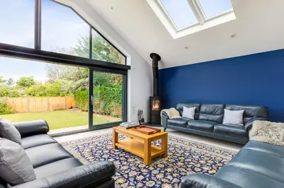 a living room with two couches and a table at The Garden House in Wadebridge