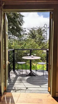 a patio with a table and chairs on a balcony at The Applehay in Constantine