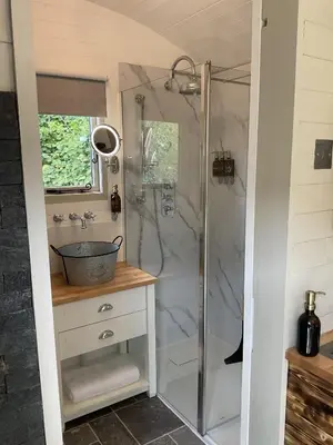 a bathroom with a shower and a sink at Gillan Creek Retreat in Helston