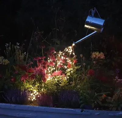 a light in a flower garden at night at Gillan Creek Retreat in Helston