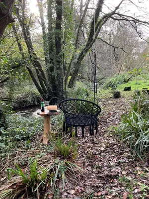 a swing and a table and a bench in a park at Gillan Creek Retreat in Helston
