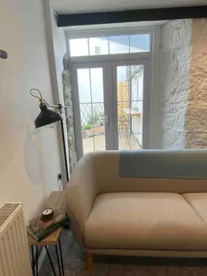 a living room with a couch and a window at Foundry cottage in Hayle