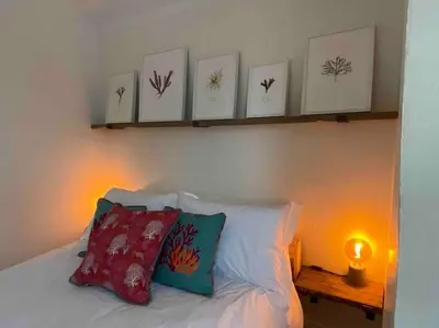 a bedroom with a bed with four pictures on the wall at Foundry cottage in Hayle
