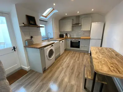 a kitchen with a washer and dryer in it at Foundry cottage in Hayle
