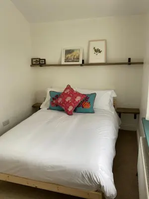 a bedroom with a white bed with two pillows on it at Foundry cottage in Hayle