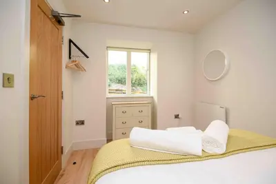 a white bedroom with a bed and a window at Crow's Nest, Polperro in Polperro