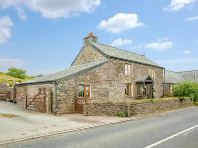 an old stone house on the side of the road at Railway Cottage in Camelford