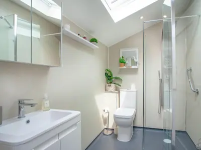 a bathroom with a toilet and a sink and a shower at Railway Cottage in Camelford