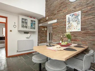 a kitchen and dining room with a wooden table and chairs at Railway Cottage in Camelford