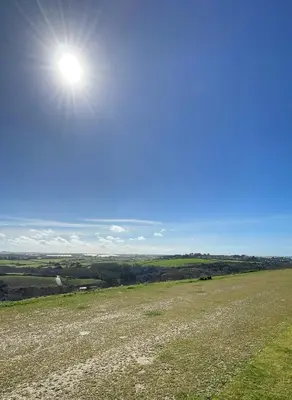 a field with the sun in the sky at Holiday Home with Stunning Views in Newquay