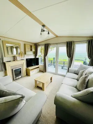 a living room with couches and a television and a table at Holiday Home with Stunning Views in Newquay