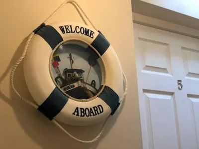 a welcome aboard mirror hanging next to a door at Beach Side Top Floor Property, Balcony & Sea Views in Newquay