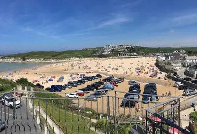 a beach with a bunch of cars parked on the sand at Beach Side Top Floor Property, Balcony & Sea Views in Newquay