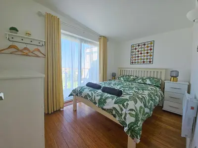 a bedroom with a bed and a large window at Ocean Swell (49) in Bude