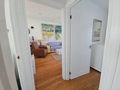 an open door to a living room with a couch at Ocean Swell (49) in Bude