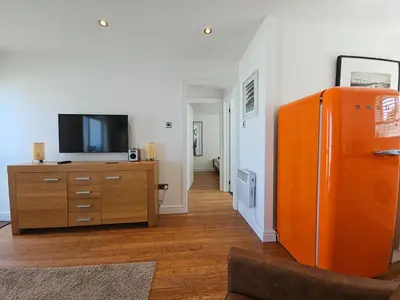 a living room with an orange refrigerator and a tv at Ocean Swell (49) in Bude