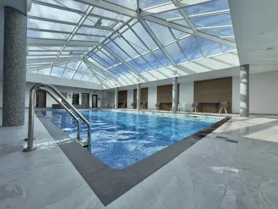 a large indoor swimming pool with a glass ceiling at Ocean Swell (49) in Bude