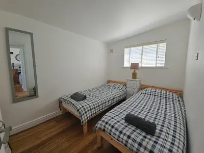 two twin beds in a room with a mirror at Ocean Swell (49) in Bude