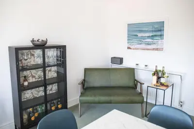 a living room with a chair and a wine rack at Newquay Tamarisk Lodge on the Gannel in Newquay