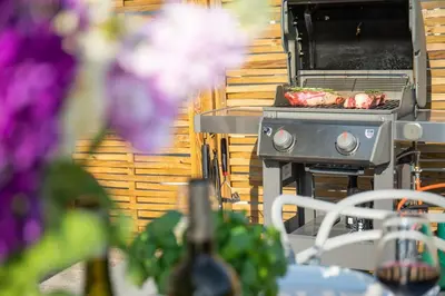 a grill with two hot dogs on top of it at Newquay Tamarisk Lodge on the Gannel in Newquay