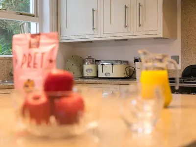 a kitchen counter with a glass jar of apples on it at Glenside House in Carbis Bay